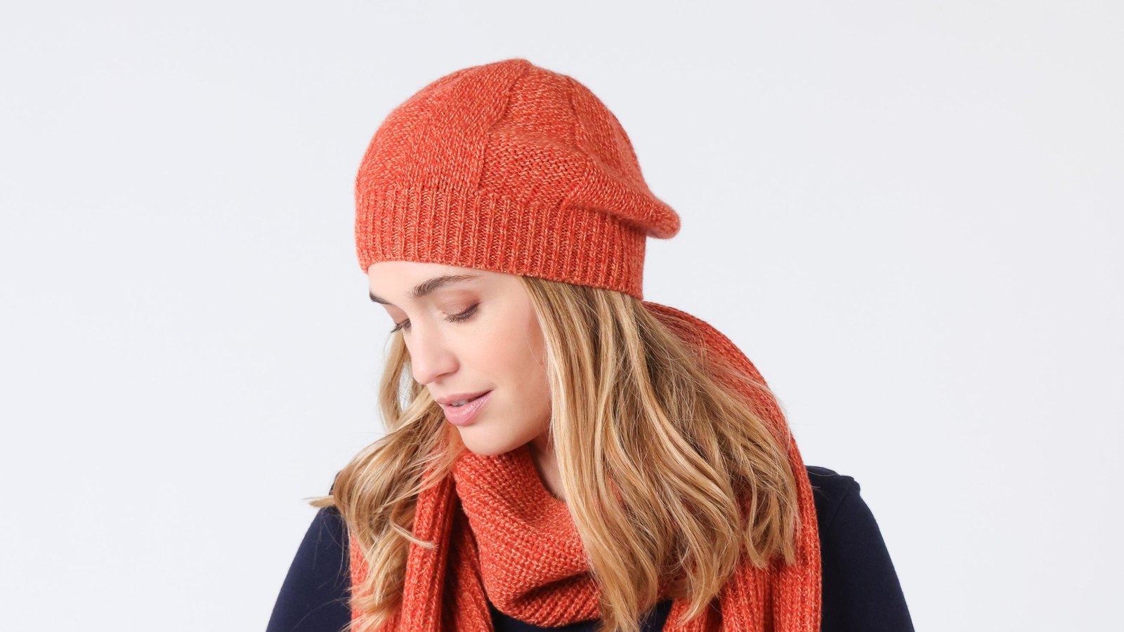 Femme portant un béret et une écharpe en laine orange mouliné