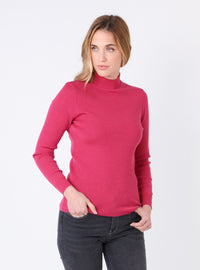 Femme portant un pull col cheminée en laine mérinos rose géranium, vue de face