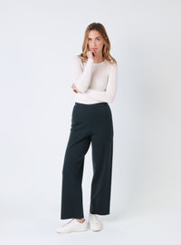 Pantalon femme en laine mérinos vert sombre, vue de face porté avec un pull clair